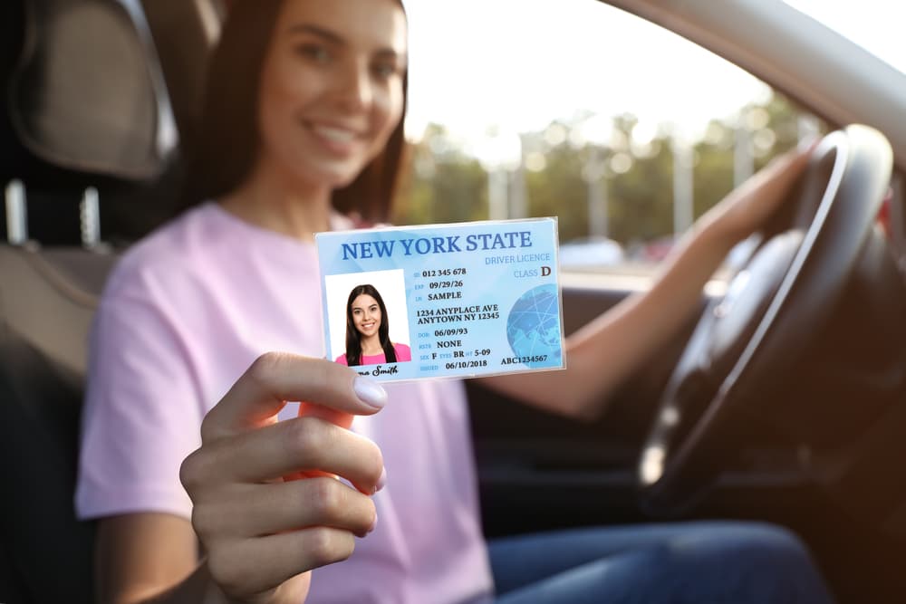 In the car, a young woman sits with a beaming smile, clutching her driver's license tightly in her hand. After a long period of suspension, she's finally back on the road. 
