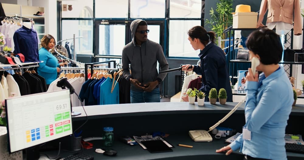 An African American man tries to steal a stylish shirt but is caught by a store security guard in a shopping mall. The Asian bodyguard asks the thief to return the fashionable item.